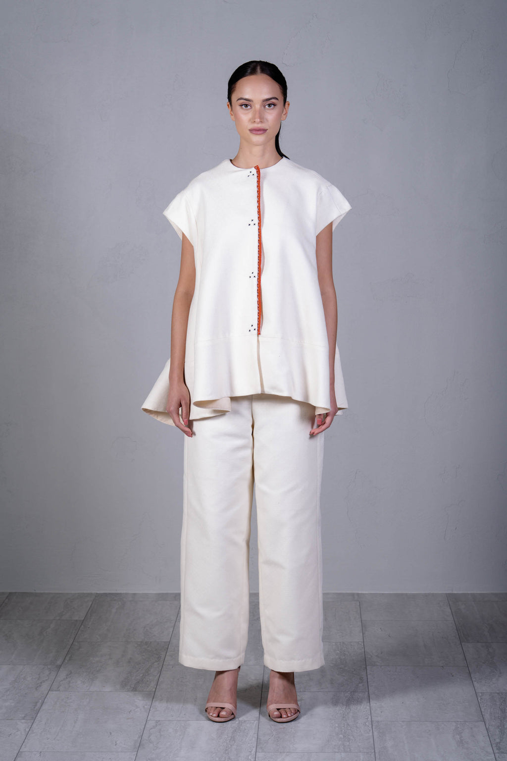 Woman wearing a white outfit with a plain background