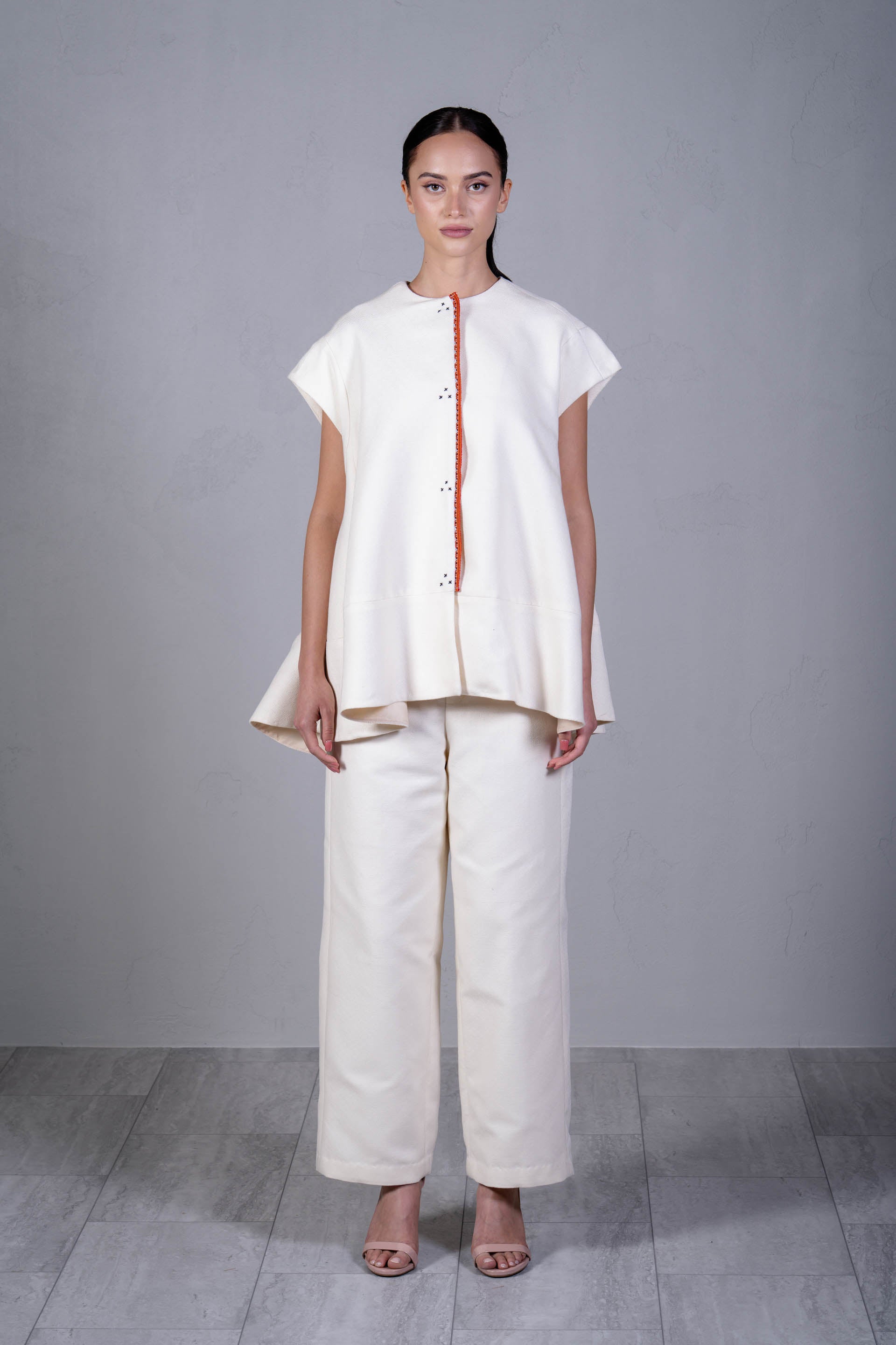 Woman wearing a white outfit with a plain background